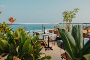 a patio with tables and chairs and the ocean at Amber Beach Hotel at Hulhumale in Hulhumale