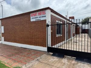 a gate to a brick building with a sign on it at Apart Hotel ONCATIVO in Oncativo