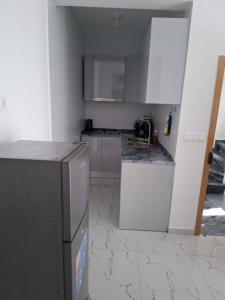 a kitchen with white cabinets and a refrigerator at Casa do Céu Azul in Tarrafal