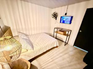 ein kleines Schlafzimmer mit Bett und Fernseher in der Unterkunft Toba hotel in Ibagué