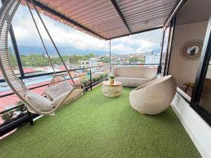 ein Balkon mit Stühlen und einer Hängematte an einem Gebäude in der Unterkunft Toba hotel in Ibagué