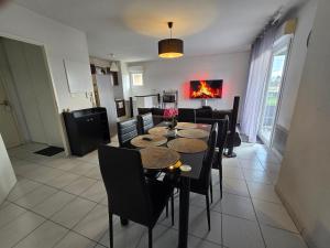 a living room with a dining room table and chairs at T2 Confort - Clim, Piscine & Parking privé in Montauban