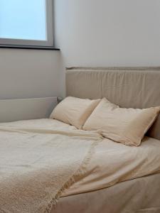 an unmade bed in a bedroom with a window at Modern, bright apartment for individuals & groups in Remscheid