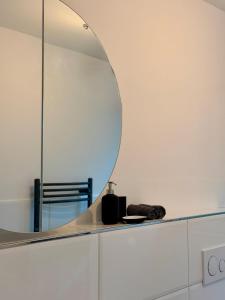 a bathroom with a mirror on a white cabinet at Modern, bright apartment for individuals & groups in Remscheid