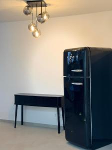 a black table next to a black table and a refrigerator at Modern, bright apartment for individuals & groups in Remscheid