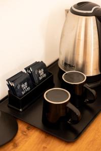 a tea pot and two tea cups on a black tray at OMNYA Nungwi Boutique Hotel in Nungwi