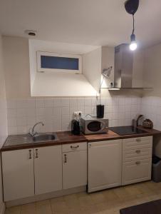 a small kitchen with a sink and a microwave at Le coin tranquille in Rodez