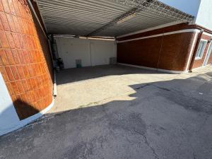 an empty garage with a brick wall and a building at Apart Hotel ONCATIVO in Oncativo +18 photos