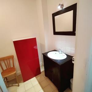 a bathroom with a sink and a mirror and a chair at Le coin tranquille in Rodez +4 photos