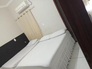 a small room with a bed and a radiator at Hotel São Jorge in Brumado