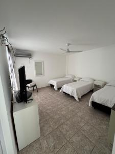 a room with two beds and a flat screen tv at Apart Hotel ONCATIVO in Oncativo