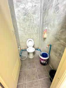 a small bathroom with a toilet and a bucket at RSP Hostel รักษ์สุพรโฮสเทล in Ban Hua Thung
