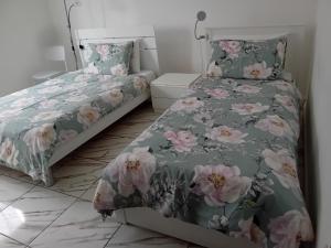 a bedroom with two beds with pink flowers at Villa Azzurra in Monfalcone