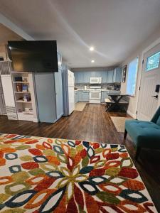 a large living room with a kitchen and a rug at Less is Moore in Thompsonville
