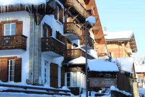 a building with balconies and snow on the ground at Le Chalet d'Antoine - Centre de Megève in Megève