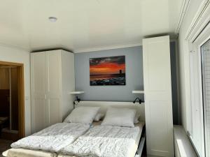 a bedroom with a bed with a painting on the wall at Bungalow Löwenstrom in Büsum