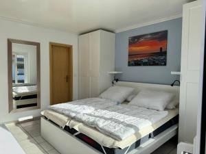 a bedroom with a bed with a painting on the wall at Bungalow Löwenstrom in Büsum