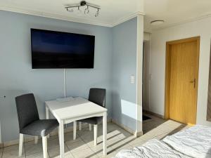 a bedroom with a white table and two chairs and a bed at Bungalow Löwenstrom in Büsum