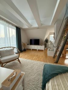 a living room with a staircase and a couch at Gemütliche Galeriewohnung im Grünen in Trappenkamp