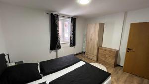 a bedroom with a black and white bed and a window at Haus Vranjes in Rosenau am Hengstpass