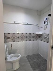 a bathroom with a toilet and a phone on the wall at Atchanin camping room 2 in Ban Samet