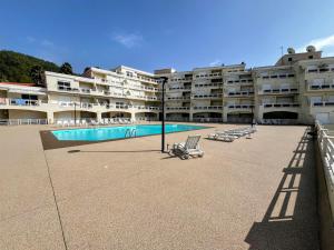 a large apartment building with a swimming pool and chairs at BEACH house in Sesimbra