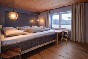 a bedroom with a large bed and a window at Stadtappartement Saalfelden in Saalfelden am Steinernen Meer