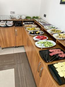 a buffet line with many plates of food at Marvarid Hotel in Ghijduwon