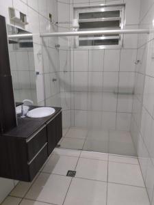 a bathroom with a sink and a shower at Mar e sol in Itanhaém