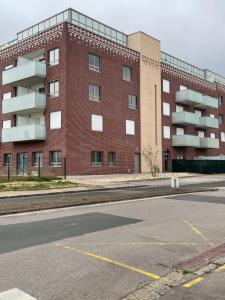 an empty parking lot in front of a brick building at Gîte chti picard parking privé gratuit ,wifi et 100m de la plage in Berck-sur-Mer