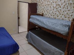 a room with two bunk beds and a mirror at Mar e sol in Itanhaém