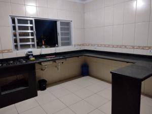 an empty kitchen with a sink and a window at Mar e sol in Itanhaém +7 photos