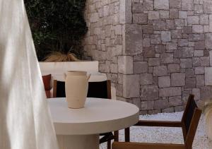 a white table with a vase sitting on top of it at The Village by WPS in Pollonia +23 photos