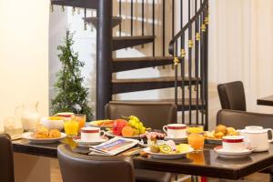パリにあるホテル アンペリアル パリの朝食用の食材とオレンジジュースを用意した朝食用テーブル