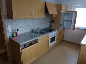 a small kitchen with wooden cabinets and a sink at Ferienwohnung Neifer in Bad Überkingen