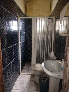 a bathroom with a sink and a toilet and a shower at Casa 2 quartos em frente a praia na cidade mística de colares a 96 quilômetros de Belém do Pará in Colares