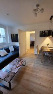 a living room with a couch and a table at Moderne 3-Zimmer-Wohnung mit separatem Eingang in Donauwörth