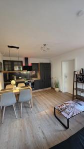 a living room with a table and a kitchen at Moderne 3-Zimmer-Wohnung mit separatem Eingang in Donauwörth +4 photos