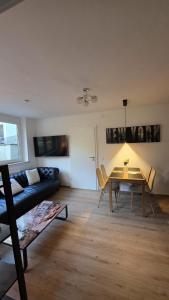 a living room with a table and a couch at Moderne 3-Zimmer-Wohnung mit separatem Eingang in Donauwörth