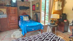 a bedroom with a bed and a brick wall at Cabaña Renacer in Samaipata +122 photos
