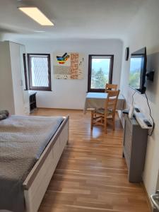 a bedroom with two beds and a table and a desk at Turistična kmetija Sušek in Muta