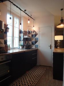 uma cozinha com um lavatório e uma janela em Les appartements d artiste de la Villa du 15 - Restaurant La Maison - piscine chauffée em Les Eyzies-de-Tayac