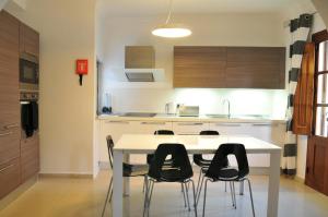 uma cozinha com uma mesa branca e cadeiras pretas em Luxury Apartment Marble Arch em St. Julian's