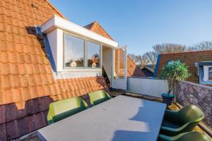 a table and chairs on a patio with a house at Zilt in Hollum