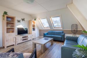 a living room with a couch and a tv at Zilt in Hollum