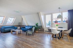 a living room with a couch and a table and chairs at Zilt in Hollum