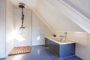 a bathroom with a shower and a bath tub at Zilt in Hollum +21 photos