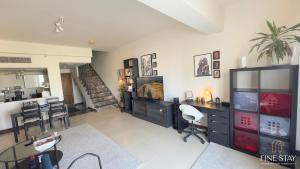 a living room with a television and a table and chairs at Modern 2BR Duplex in New Cairo Quiet Area, Balcony & Fast WiFi in Cairo