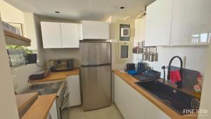 a kitchen with white cabinets and a stainless steel refrigerator at Modern 2BR Duplex in New Cairo Quiet Area, Balcony & Fast WiFi in Cairo