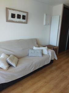 a white bed with pillows on it in a room at Le Grand Large in Gruissan